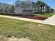 Community entrance sign for Harmony, framed by colorful flowerbeds and a sidewalk at 1114 Brimstone Cir, Winter Haven, FL 33884
