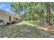 Well-kept backyard with manicured lawn, patio area, and view of the home's exterior at 11569 Sw 75Th Cir, Ocala, FL 34476