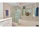 A bathtub sits beneath a window in a bathroom with a glass shower and floral wallpaper at 11569 Sw 75Th Cir, Ocala, FL 34476