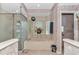 A bathtub sits beneath a window in a bathroom with a glass shower and floral wallpaper at 11569 Sw 75Th Cir, Ocala, FL 34476