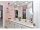 A bathroom vanity with double sinks, white cabinets, and a large mirror at 11569 Sw 75Th Cir, Ocala, FL 34476