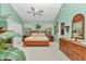 Spacious main bedroom with wood furniture and a ceiling fan, featuring a green color scheme at 11569 Sw 75Th Cir, Ocala, FL 34476