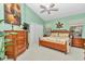 Spacious main bedroom with wood furniture and a ceiling fan, featuring a green color scheme at 11569 Sw 75Th Cir, Ocala, FL 34476