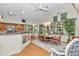 Open-concept dining area with hardwood floors, modern lighting, and multiple windows at 11569 Sw 75Th Cir, Ocala, FL 34476