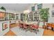 A bright dining room features a chandelier, hardwood floors, a wooden table, and large windows at 11569 Sw 75Th Cir, Ocala, FL 34476