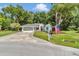Charming single-story home featuring a well-manicured lawn, American flag and a welcoming two-car garage with paved driveway at 11569 Sw 75Th Cir, Ocala, FL 34476