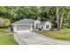 Charming single-story home featuring a well-manicured lawn and a welcoming two-car garage with paved driveway at 11569 Sw 75Th Cir, Ocala, FL 34476