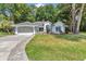 Charming single-story home featuring a well-manicured lawn and a welcoming two-car garage with paved driveway at 11569 Sw 75Th Cir, Ocala, FL 34476