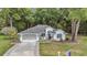 Charming single-story home featuring a well-manicured lawn and a welcoming two-car garage with paved driveway at 11569 Sw 75Th Cir, Ocala, FL 34476