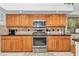 Well-lit kitchen featuring wood cabinets, stainless steel appliances, and granite countertops at 11569 Sw 75Th Cir, Ocala, FL 34476