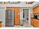 Functional kitchen featuring wood cabinetry, stainless steel appliances, and a walk-in pantry at 11569 Sw 75Th Cir, Ocala, FL 34476
