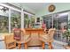 Bright sunroom features a cozy bar area with tropical decor, ideal for entertaining guests at 11569 Sw 75Th Cir, Ocala, FL 34476