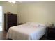 Bedroom featuring a white bedspread, nightstands, and a chest of drawers at 11628 Sw 140Th Loop, Dunnellon, FL 34432