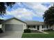 Charming single-story home with a screened garage, manicured lawn, and inviting curb appeal at 11628 Sw 140Th Loop, Dunnellon, FL 34432