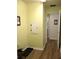 Hallway with door to the bathroom; neutral colored walls and wood look flooring at 11628 Sw 140Th Loop, Dunnellon, FL 34432