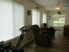 Spacious living room featuring a ceiling fan, two recliners, and an exercise bike at 11628 Sw 140Th Loop, Dunnellon, FL 34432