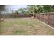 Fenced in backyard featuring a lawn and mature landscaping on a sunny day at 12 Brook Pl, Ocala, FL 34472