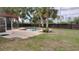 Backyard pool surrounded by a concrete patio, mature landscaping, and wooden fence at 12 Brook Pl, Ocala, FL 34472