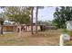 Cozy single-story home with a covered carport, mature trees, and a spacious front lawn at 12 Brook Pl, Ocala, FL 34472