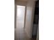 Hallway with access to bedroom and bathroom, featuring neutral paint and tiled floors at 12 Brook Pl, Ocala, FL 34472