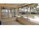 Enclosed patio overlooks the backyard with mature trees and pump equipment at 12 Brook Pl, Ocala, FL 34472