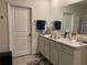 Bathroom vanity with double sinks, ample storage, and a large mirror at 12 Hickory Course Way, Ocala, FL 34472