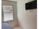 Simple bedroom featuring a mounted flat screen television and natural lighting at 12 Hickory Course Way, Ocala, FL 34472