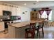 Modern kitchen with stainless steel appliances, granite countertops, and a breakfast bar overlooking the dining area at 12 Hickory Course Way, Ocala, FL 34472