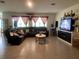 Spacious living room featuring tile flooring, comfortable seating, and an entertainment center, perfect for relaxation and entertainment at 12 Hickory Course Way, Ocala, FL 34472