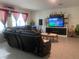 Cozy living room with comfortable seating, entertainment center, and a light-filled atmosphere for relaxed living and entertainment at 12 Hickory Course Way, Ocala, FL 34472