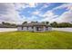 The backyard features a well-maintained lawn, white fence, and a covered patio, perfect for outdoor entertaining at 12180 Se 89Th Ter, Belleview, FL 34420
