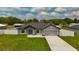 Charming single-story home with manicured lawn, neutral paint, grey roof, and a two-car garage at 12180 Se 89Th Ter, Belleview, FL 34420