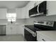 Modern kitchen with stainless appliances, white cabinetry and a black sink fixture at 12180 Se 89Th Ter, Belleview, FL 34420