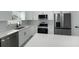Modern kitchen featuring stainless steel appliances, quartz countertops, and white cabinets with black hardware at 12180 Se 89Th Ter, Belleview, FL 34420