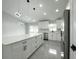 Modern white kitchen with an island and stainless steel appliances at 12180 Se 89Th Ter, Belleview, FL 34420