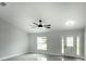 Bright living room with large windows, ceiling fan, and tile flooring at 12180 Se 89Th Ter, Belleview, FL 34420
