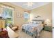 Comfortable bedroom offers natural light, a ceiling fan, and views of the adjacent golf course at 12255 Se 177Th Loop, Summerfield, FL 34491