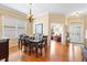 Open dining area with hardwood floors, a decorative chandelier, and an adjacent living room at 12255 Se 177Th Loop, Summerfield, FL 34491
