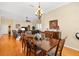 Dining area showcasing an elegant chandelier, hardwood floors, and an adjacent living room at 12255 Se 177Th Loop, Summerfield, FL 34491