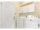 Bright laundry room features a white door, cabinets, and white Maytag washer and dryer at 12255 Se 177Th Loop, Summerfield, FL 34491