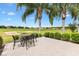 Outdoor patio has seating near golf course, framed by swaying palm trees and manicured landscaping at 12255 Se 177Th Loop, Summerfield, FL 34491