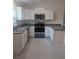 Modern kitchen featuring white cabinets, stainless steel appliances, and gray countertops at 15 Juniper Trail Crse, Ocala, FL 34480