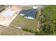 Aerial view of a newly built home with dark roof, lush backyard, and the foundation of another home nearby at 16890 Sw 39Th Cir, Ocala, FL 34473