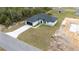 Exterior shot of a single-Gathering home, dark roof, contrasted against the green grass and blue skies above at 16890 Sw 39Th Cir, Ocala, FL 34473