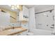Bright bathroom features a shower and tub combination with white tiling and a cultured marble countertop at 1736 Watts Mill Way, The Villages, FL 32162