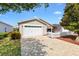 Charming home exterior featuring a two-car garage, tidy landscaping, and a welcoming front walkway at 1736 Watts Mill Way, The Villages, FL 32162