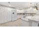 Bright kitchen with tiled countertops, white cabinetry, breakfast bar and stainless appliances at 1736 Watts Mill Way, The Villages, FL 32162