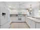 Bright kitchen featuring tiled countertops, white cabinetry, breakfast bar and stainless appliances at 1736 Watts Mill Way, The Villages, FL 32162