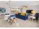 Open living area with tile flooring, recessed lighting, and a blue couch next to the dining space at 1736 Watts Mill Way, The Villages, FL 32162