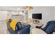 Open-concept living area with a large tv, tile floors, and adjacent kitchen at 1736 Watts Mill Way, The Villages, FL 32162